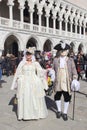 Masked couple walking in Venice