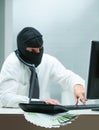 Masked criminal, computer, European bills, risks evident Royalty Free Stock Photo