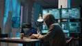 Masked data thief hacking computer network at night,