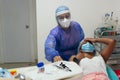 Masked dentist performing dental treatment procedure in the dental clinic