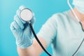 Masked doctor with a stethoscope in hand close-up. Concept for medical examination, seasonal diseases, heart diseases and