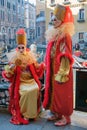 Masked and dressed up couple in reds posing on the street