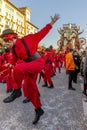 Masked figures dancing on the street with the allegorical float `Idol` in the background, Carnival of Viareggio, Italy