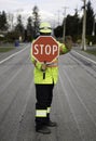 Masked flagger at work holding stop sign