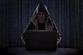 masked hacker using smartphone. Hacking the Internet.