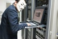 Masked Hacker in Computer Server room Concept .