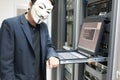 Masked Hacker in Computer Server room Concept .