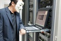 Masked Hacker in Computer Server room Concept .