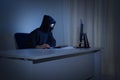 Masked hacker in front at computer into dark room. Internet security concept Royalty Free Stock Photo