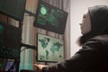 Masked hacker with a hoodie using computer to plan a massive cyber attack