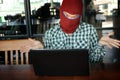 Masked hacker wearing a balaclava looking a laptop after stealing important information data. Internet crime concept. Royalty Free Stock Photo