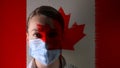 Masked man on the background of the flag of Canada. The epidemic, the dangerous virus of the crown of 2020. Infection and mass