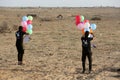 Masked Palestinians of the Popular Resistance Committees prepare incendiary balloons to be flown towards Israel