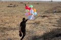 Masked Palestinians of the Popular Resistance Committees prepare incendiary balloons to be flown towards Israel