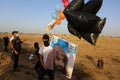 Masked Palestinians of the Popular Resistance Committees prepare incendiary balloons to be flown towards Israel
