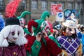 Masked people wearing traditional costume playing flute parading in the street