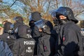 Masked policemen with mask and helmet in black uniforms Royalty Free Stock Photo