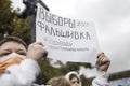 Masked Protestant holding a poster with the slogan: Election 2021 - Fake! Freedom for political prisoners