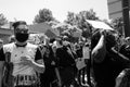 Masked protestors chant and hold signs in protest of the killing of George Floyd