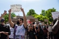 Masked protestors chant and hold signs in protest of the killing of George Floyd