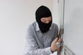 Masked robber using a lock picking tool to breaking and entering into a house. Criminal crime concept. Royalty Free Stock Photo