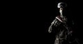 A masked soldier holds a rifle in his hands on a black background Royalty Free Stock Photo