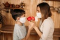 A masked son gives flowers to a masked mom. Mother`s Day on self-isolation. Family quarantined Royalty Free Stock Photo