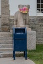 Masked statue with post office box