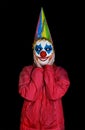 Masked surprised clown man on isolated black background Royalty Free Stock Photo