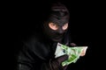 Masked thief in balaclava with stolen money isolated on black Royalty Free Stock Photo