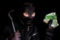 Masked thief in balaclava with stolen money isolated on black Royalty Free Stock Photo