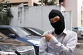 Masked thief in black balaclava trying to break into car Royalty Free Stock Photo