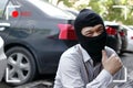 Masked thief in black balaclava trying to break into car with cctv camera viewfinder display. Criminal crime concept. Royalty Free Stock Photo