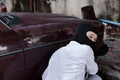 Masked thief in black balaclava trying to break into car. Criminal crime concept Royalty Free Stock Photo