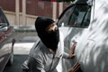 Masked thief in black balaclava trying to break into car. Criminal crime concept Royalty Free Stock Photo