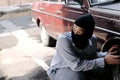 Masked thief in black balaclava trying to break into car. Criminal crime concept. Royalty Free Stock Photo