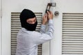 Masked thief in black balaclava trying to break into house Royalty Free Stock Photo