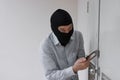 Masked thief in black balaclava trying to break into house Royalty Free Stock Photo