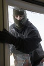 Masked Thief Breaking In Through Window Royalty Free Stock Photo