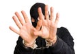 Masked thief in handcuffs isolated on white background