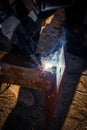 Masked welder welds metal at a construction site