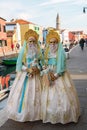 Masked Women with dolls in dresses posing on the street, Venice, Italy