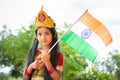 Maski, India August 15, 2019 : Small cute little Indian Girl kid in Bharat mata or Mother India attire with Indian Flag in hand