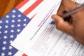 Maski, India - 23, June 2020 : Close up of hands filling President voter Registration Application with US flag as