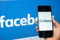 Maski, India - October 29, 2021 : Close up of hands holding Meta facebook`s new name on mobile phone with facebook new logo on