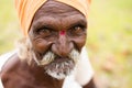 Closeup of a happy elderly Indian man wearing a headscarf and smiling into the camera