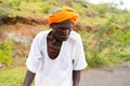 Closeup of an Indigenous Tribal Indian elderly man wearing a headscarf outdoors in Maski, India