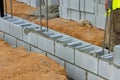 A mason bricklayer worker is laying the mounting a wall of aerated concrete blocks for building Royalty Free Stock Photo