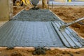 Mason building a screed coat cement at floor work. pouring concrete pavement Royalty Free Stock Photo