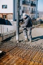 Mason building and worker using a automatic cement pump and levelling a first layer of fresh concrete Royalty Free Stock Photo
